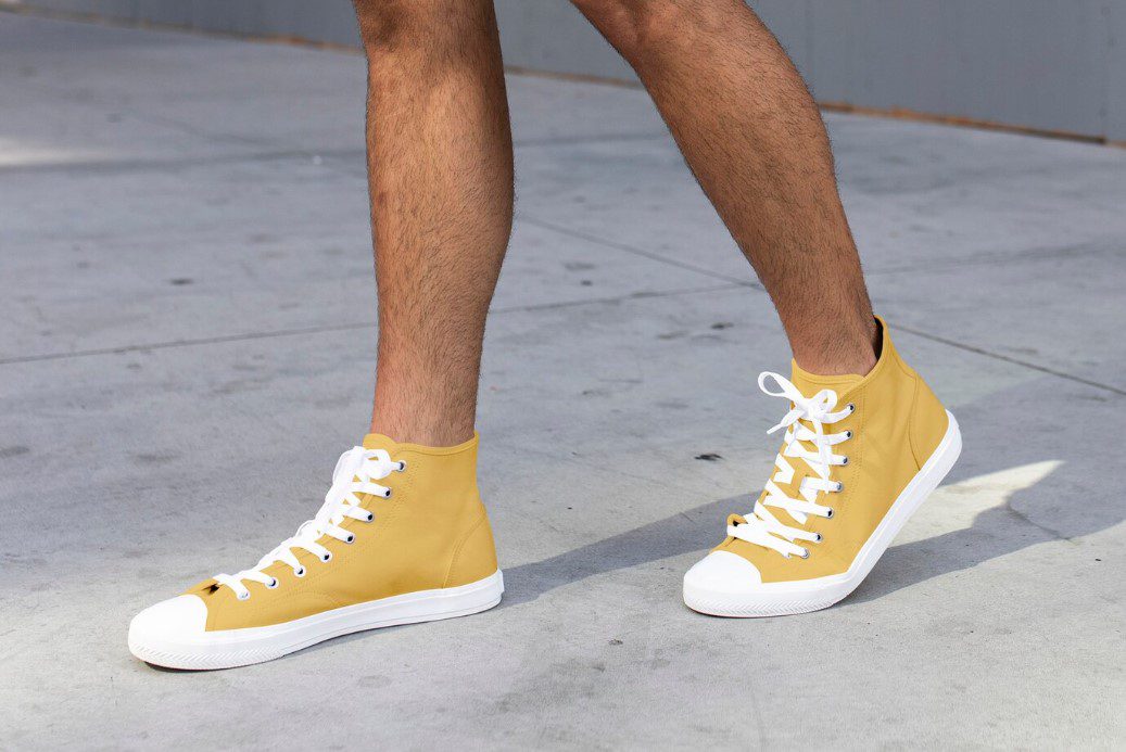 homem utilizando um tênis para sair amarelo