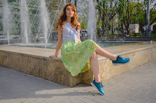 mulher sentada na praça de tênis com vestido